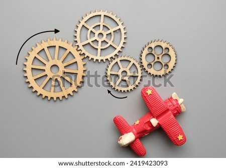 Flatlay picture of wooden gear with aeroplane. Technical and mechanical concept
