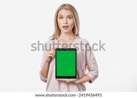 Surprised caucasian woman showing tablet computer isolated on white background. Green screen mockup for free empty copy space. Advertisement concept