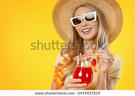 Close up of young woman posing isolated over yellow background and drinking cocktail. Beach resort holiday weekends days off in summer