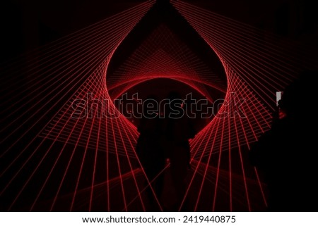 a red laser display cuts through the silhouette of a group of people in the middle. background that can be used as a design asset or editing resource. Clubbing, dance music theme