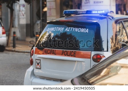 Athens Municipal Police car with siren, "Municipal Police" logo emblem, Greek police squad car with emergency flashing lights on duty maintain public order in the streets of Athens, Attica, Greece
