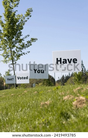 Low angle view of "Have You Voted Yet" lawn signs with clear blue sky in the background. Election Day concept.
