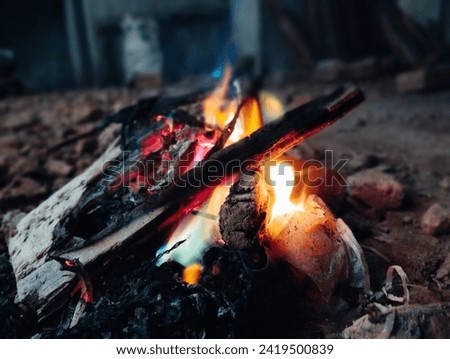 The picture shows a bright, hot fire. Flames dance and flicker, casting a warm glow. The colors are mainly red, orange, and yellow. It looks powerful and energetic