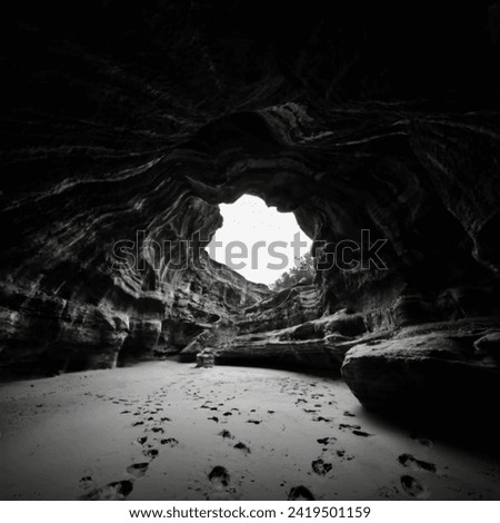 black and white photograph of the interior of a cave that looks like a pinhole camera, photo