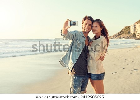 Couple, selfie and smile for hug by sea for memory on vacation with care, love and tropical beach. Man, woman and smartphone screen for photography, profile picture and app at ocean on social media