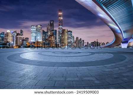 Round square floor and bridge with modern city buildings at night in Shanghai