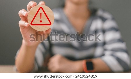 Hand holding wooden with an Exclamation mark or Warning sign with copy space concept for attention symbol, Cautionary Warning, safety, hazard, caution, danger.