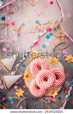 Donuts for carnival and party. German Krapfen or donuts with streamers and confetti. Colorful carnival or birthday image