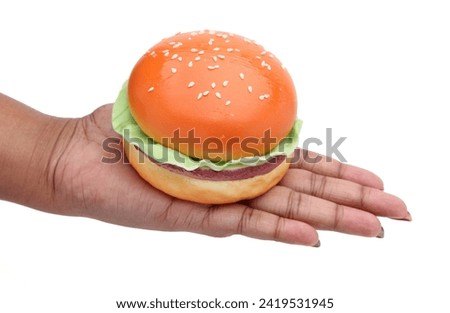 some one hand holding a artificial burger ,white background 