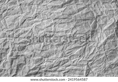 Black and white crumpled wrinkled paper background texture.