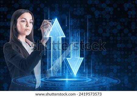 Attractive young european businesswoman using abstract up and down arrows hologram on dark blue background. The concept of digital traffic or exchange. Blue arrow technology background