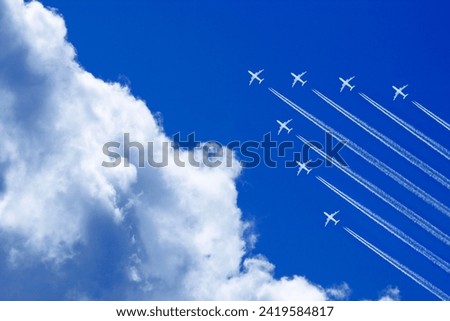 seven aeroplanes with contrails flying high in the blue sky in formation Royalty-Free Stock Photo #2419584817