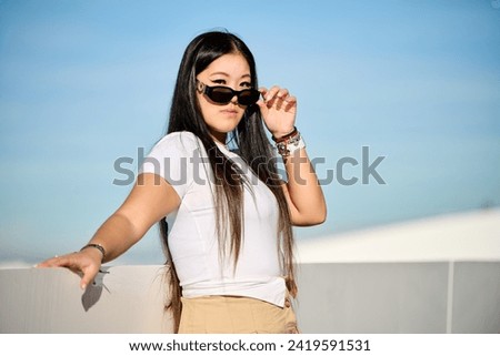 Beautiful asian woman in white t-shirt and shorts posing on the pier