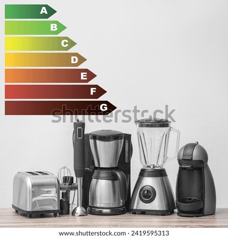 Energy efficiency rating label and kitchen appliances on wooden table