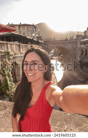 Young woman self-portrait visiting old town of Potes during sunset. Spain tourism.