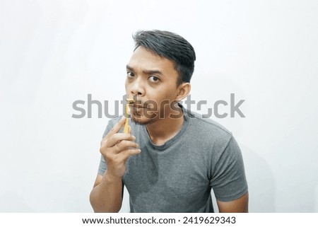 Serious Asian man shaving his mustache with manual tools Royalty-Free Stock Photo #2419629343