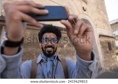 Smiling young man making pictures on a telephone