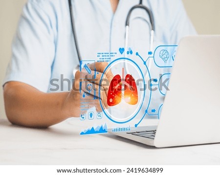 A doctor read a lung scan report on a virtual screen while sitting at a desk in a hospital. World Tuberculosis Day, World No Tobacco Day, lung cancer, pulmonary hypertension, pneumonia. Royalty-Free Stock Photo #2419634899