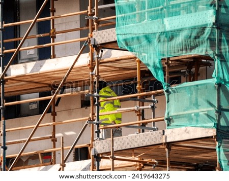 photo of a construction site with scaffolding and worker