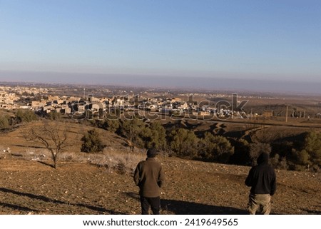 From a distant hill, witness the haunting aftermath of Amizmiz's earthquake - a shattered landscape, collapsed buildings, and debris scattered in nature's relentless wake Royalty-Free Stock Photo #2419649565