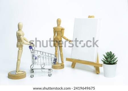 Wooden doll with shopping cart on white background. business or creative concept
