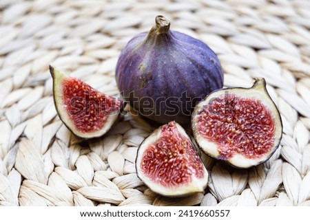 Still life of Fresh Figs lying on a plate with yellow edges, whole and cut into pieces
