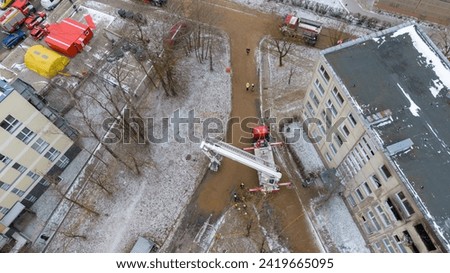 Drone photography of aftermath multistory residential building fire and emergency service cleaning up during winter cloudy day