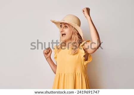 Portrait of smiling face adult woman clenching fists and rejoicing, celebrating victory isolated on white studio background, advertising banner
