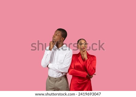 Black man and woman in white shirt and red dress, respectively, looking thoughtful with hand-on-chin poses, suggesting curiosity or decision-making, free space Royalty-Free Stock Photo #2419693047