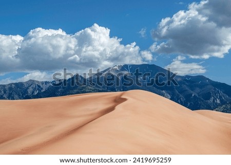 The Great Sand Dunes NP in Colorado is a hidden gem with vast dunes against a beautiful sky. It offers a surreal experience for hikers.