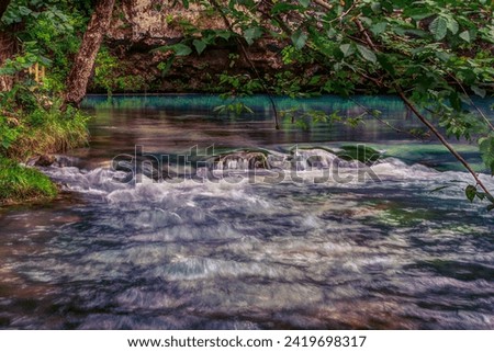 Along Current River, Missouri, is a hidden gem with a common name, Blue Spring. Nicknamed Spring of the Summer Sky, it's deep blue color is from being over 310ft deep. One of the largest in the USA. Royalty-Free Stock Photo #2419698317
