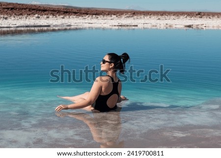 Tourist enjoys floating on salt saturated water in Laguna Baltinache, Atacama. Chile Royalty-Free Stock Photo #2419700811