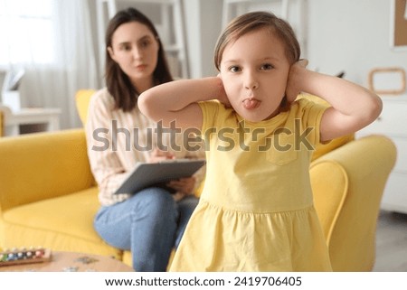 Naughty little girl at psychologist's in office Royalty-Free Stock Photo #2419706405