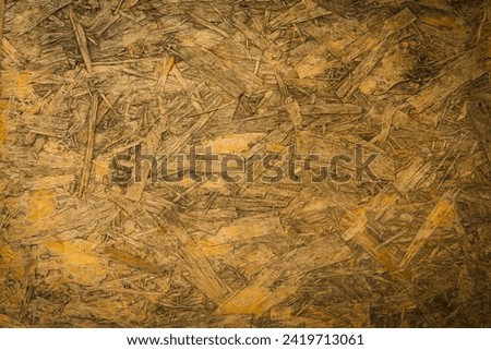 The surface of old sawdust plywood close-up horizontal clearly shows the details of the surface and the stains of the old creating a beautiful classic background and also having a vignetting effect.