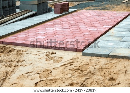 Red concrete blocks for cycle path in the sand bed