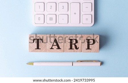 TARP on a wooden cubes with pen and calculator, financial concept
