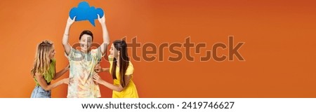 jolly diverse teens posing with blue thought bubble on orange backdrop, friendship day, banner