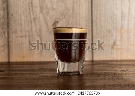 Espresso in a glass on wood background