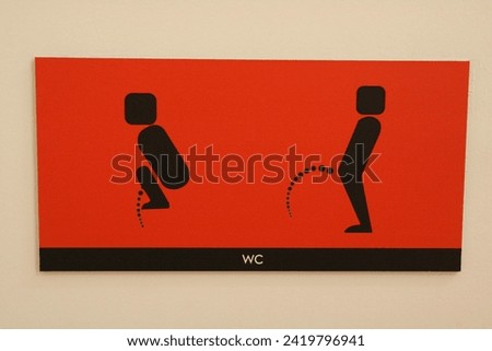Funny symbol - toilet sign in Barcelona, red sign and black figures