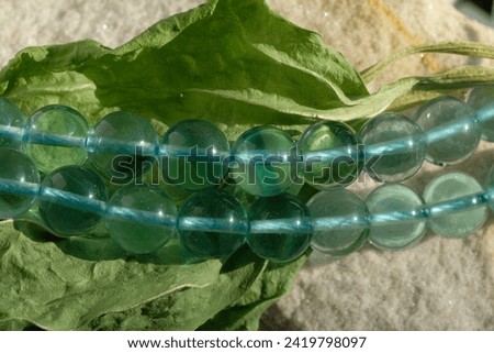 Natural green-blue fluorite on a dry plantain leaf. Royalty-Free Stock Photo #2419798097