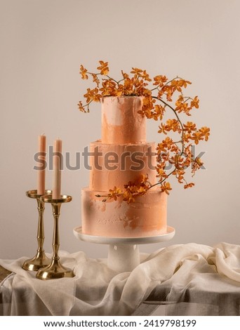 Tiered cake for wedding. Beautiful peach fuzz colored festive cake decorated with flowers