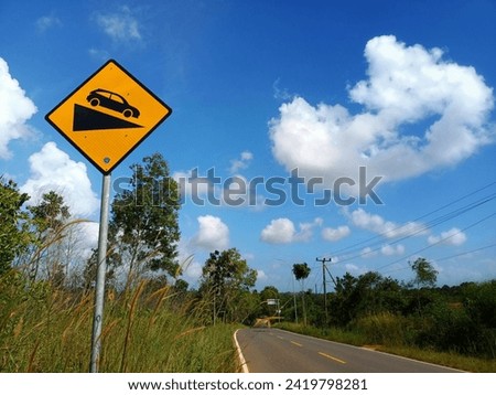 a yellow and black traffic sign in the picture is installed on the side of the road in Tanjungpinang City, Riau Islands, Indonesia
