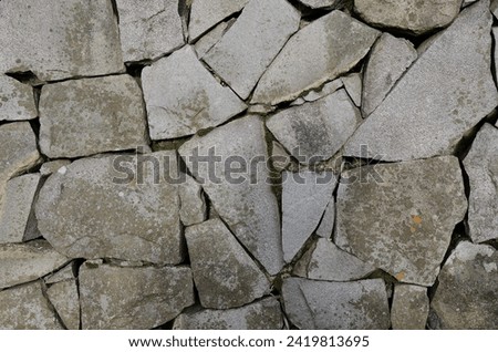 Natural grey basalt stone wall texture detail - Cobblestone Royalty-Free Stock Photo #2419813695