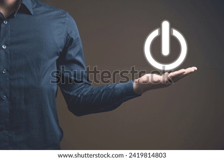 a man holding a glowing power button in his hand
