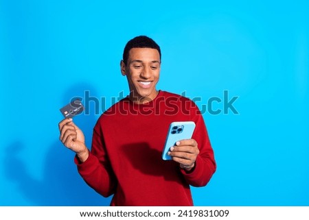 Photo of positive attractive man wear trendy red pullover pay online order cashless transaction transfer isolated on blue color background