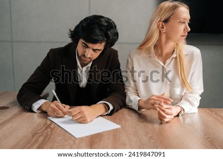 Portrait of sad spouses couple signing decree papers getting divorced in lawyers office at desk. Unhappy married family split break up end relationships giving permission to marriage dissolution. Royalty-Free Stock Photo #2419847091