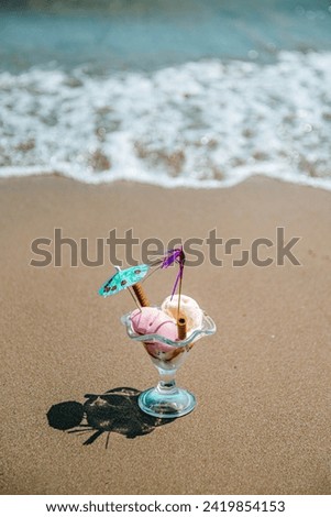 Gourmet summer dessert of artisanal or craft ice cream made with fresh berries, , pistachio nuts and  banana served in bowl next to the beach.
Summer view. Beach background with waves in greece.