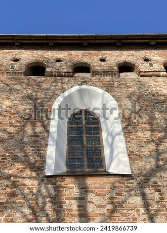 A picture of a window and an old building, warm day, blue sky