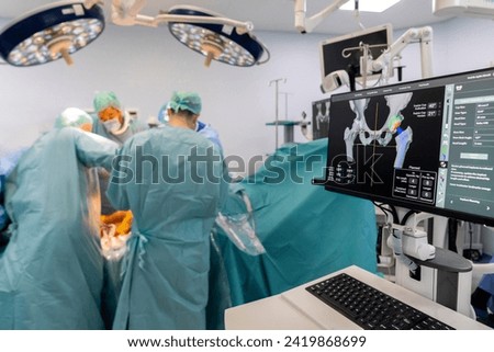 Team of doctor perform total hip arthroplasty replacement surgery in osteoarthritis patient inside the operating room. robot assisted robotic hip and knee replacement surgery	 Royalty-Free Stock Photo #2419868699