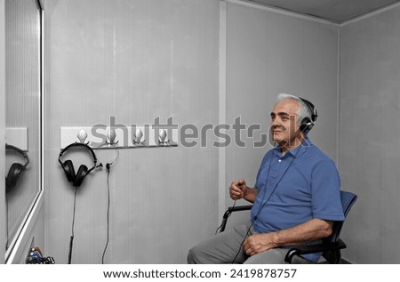 Audiologist woman doing the hearing exam to a mixed race man patient using an audiometer in a special audio room. Audiometric testing. Hearing loss treatment. Royalty-Free Stock Photo #2419878757
